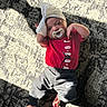 baby, infant, pacifier, headband, bow, red_shirt, jordan, nike_pants, carpet, patterned_rug, sunlight, shadow, indoor, floor, clothing, cute, relaxed, small_feet, laying_down, child