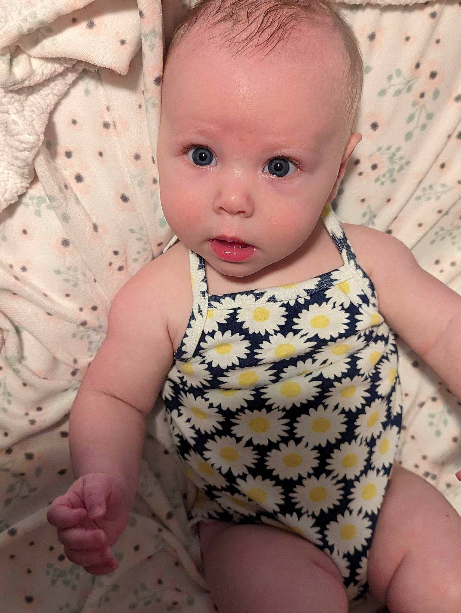 Elizabeth is registered to the contest to win money with this photo: baby, baby_toddler_clothing, cheek, chin, eye, eyelash, face, finger, hairstyle, head, human_body, iris, lip, neck, nose, person, pink, skin, sleeve, surprise