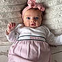 baby, infant, headband, pink_bow, dress, clothing, lying_down, blanket, soft_texture, bunny_print, cute, wide_eyes, face, child, portrait, indoors, person, adorable, small_hands, looking_at_camera