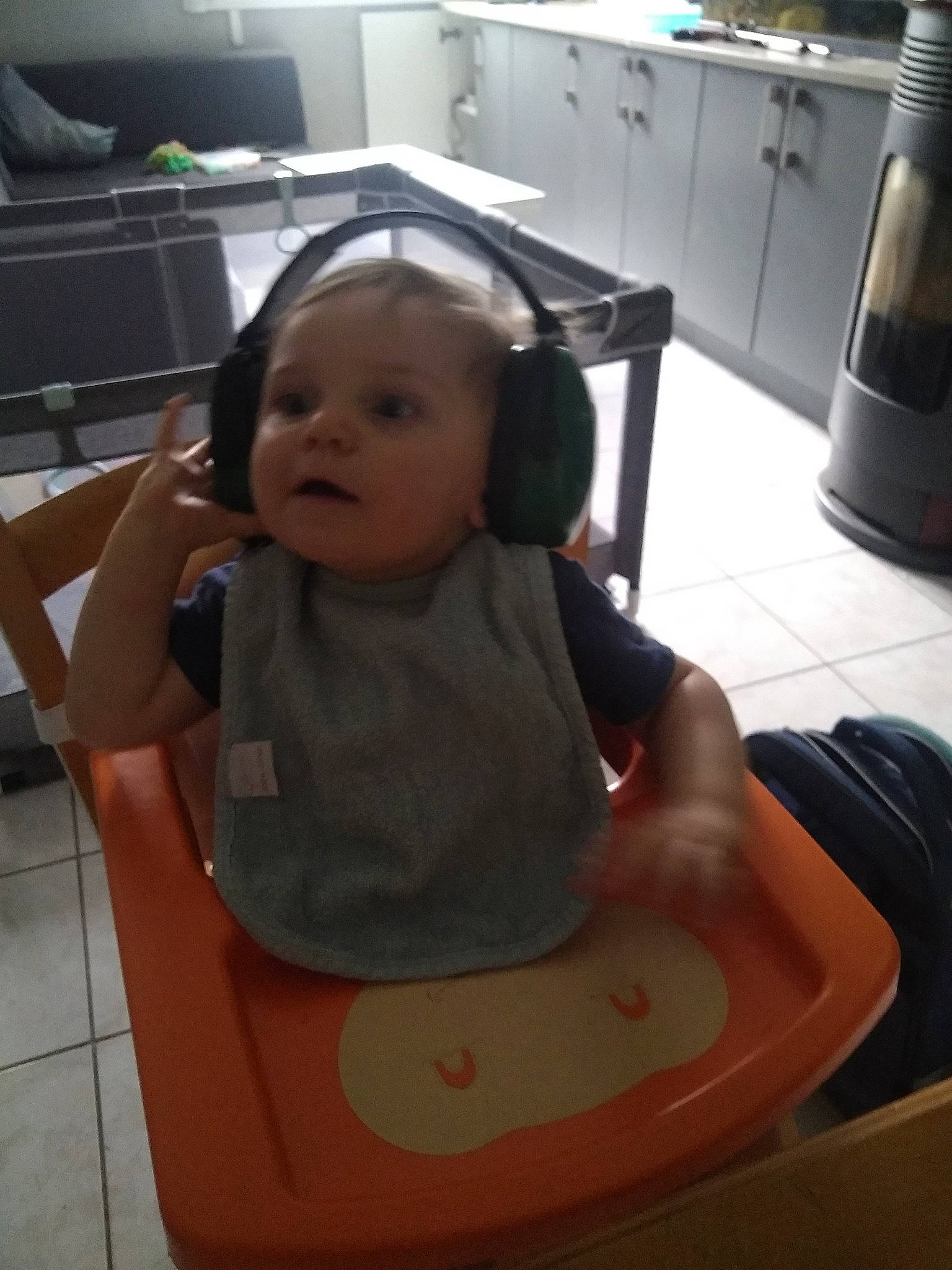 Léo participe au concours pour gagner de l'argent avec cette photo : baby, baby_toddler_clothing, cabinetry, chair, cheek, child, comfort, countertop, facial_expression, floor, flooring, fun, home_appliance, kitchen, kitchen_appliance, mouth, person, product, sitting, skin