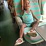 Anaya a rejoint le concours — aidez-le/la à gagner de superbes lots ! child, girl, bus_seat, striped_seat, turquoise_clothing, sandal, smiling, happy, raising_hand, public_transport, people, window_light, interior, floor, adult, casual_clothing, playful, portrait, seated, daylight