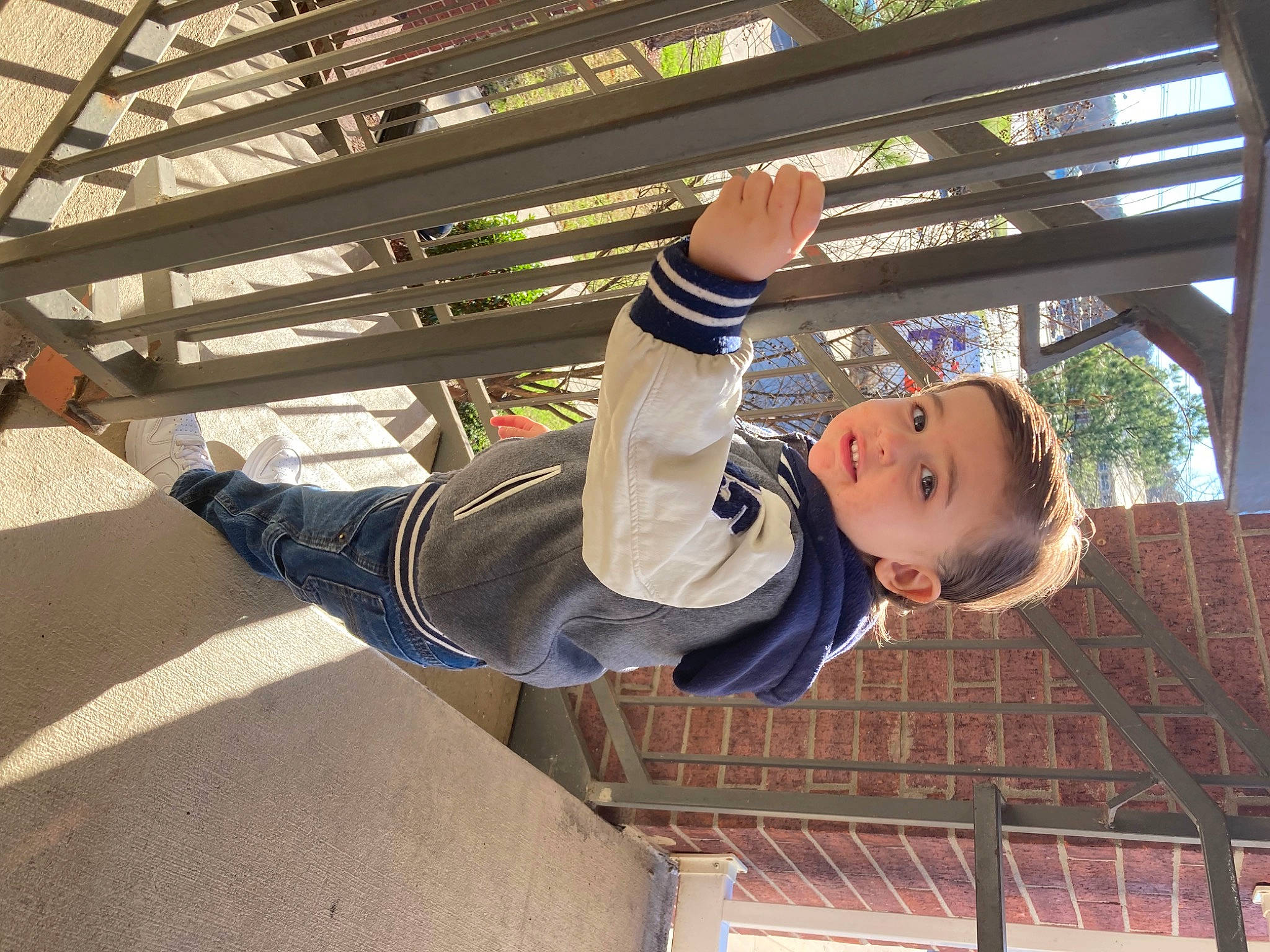 Luke is registered to the contest to win money with this photo: city, daylighting, elbow, fun, gesture, leisure, person, plant, roof, sleeve, smile, t_shirt, toddler, tree, walking_shoe, wood
