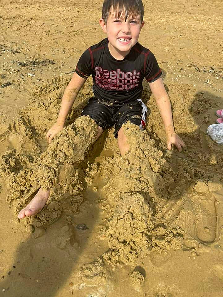 Karson joined the competition — help win amazing prizes! barefoot, beach, building_sand_castles, child, fun, happy, joy, landscape, mud, people_in_nature, people_on_beach, person, play, sand, shadow, sitting, sleeve, smile, soil, t_shirt