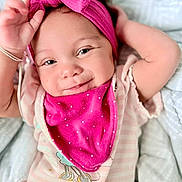 Brayah joined the competition — help win amazing prizes! baby, infant, headband, pink, smile, face, eyes, clothing, bib, blanket, lying_down, cute, child, portrait, happy, soft, comfort, baby_girl, closeup, skin