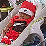 baby, sleeping, red_clothing, nike, hat, socks, baby_rocker, indoor, home, child, infant, cute, resting, comfort, toddler, furniture, soft_toy, carpet, peaceful, portrait