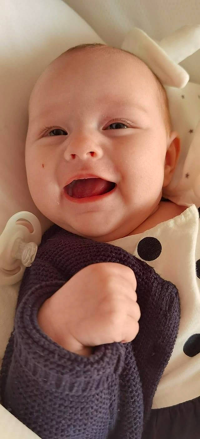 Emilia participe au concours pour gagner de l'argent avec cette photo : baby, baby_laughing, baby_toddler_clothing, cheek, child, chin, finger, gesture, happy, lip, nose, outerwear, person, pink, product, skin, sleeve, smile, textile, toddler