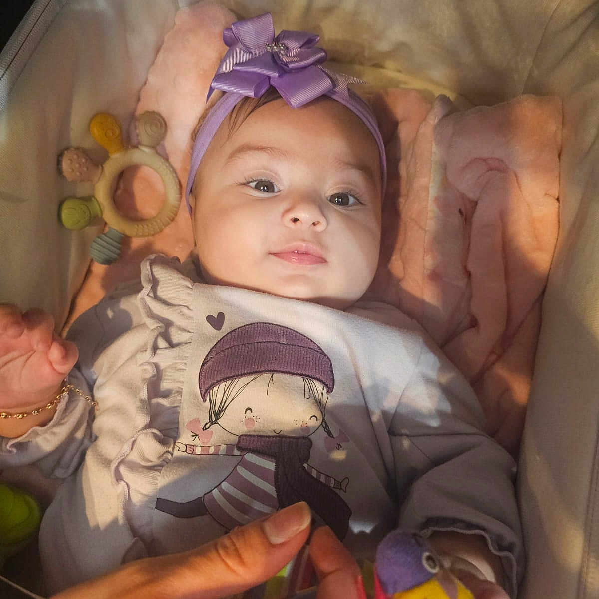 Alaya Pereira Berrio a rejoint le concours — aidez-le/la à gagner de superbes lots ! baby, bassinet, bird_toy, blanket, bow, child, closeup, clothing, cushion, cute, hand, headband, indoor, infant, person, portrait, purple, smile, soft_lighting, toy