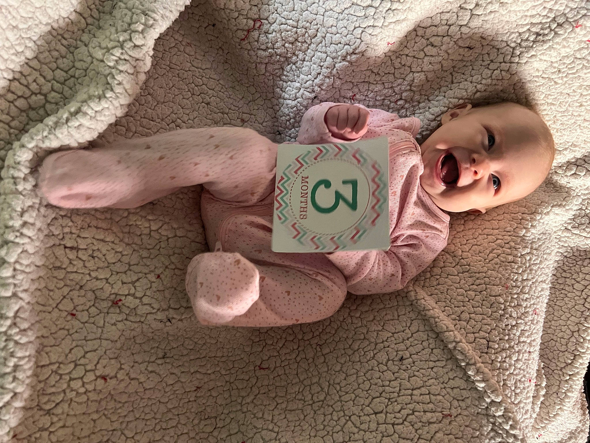 Annie is registered to the contest to win money with this photo: baby, baby_products, baby_sleeping, baby_toddler_clothing, child, comfort, flooring, foot, fur, human_body, leg, linens, nail, pattern, person, sitting, sleeve, toddler, toy, wood