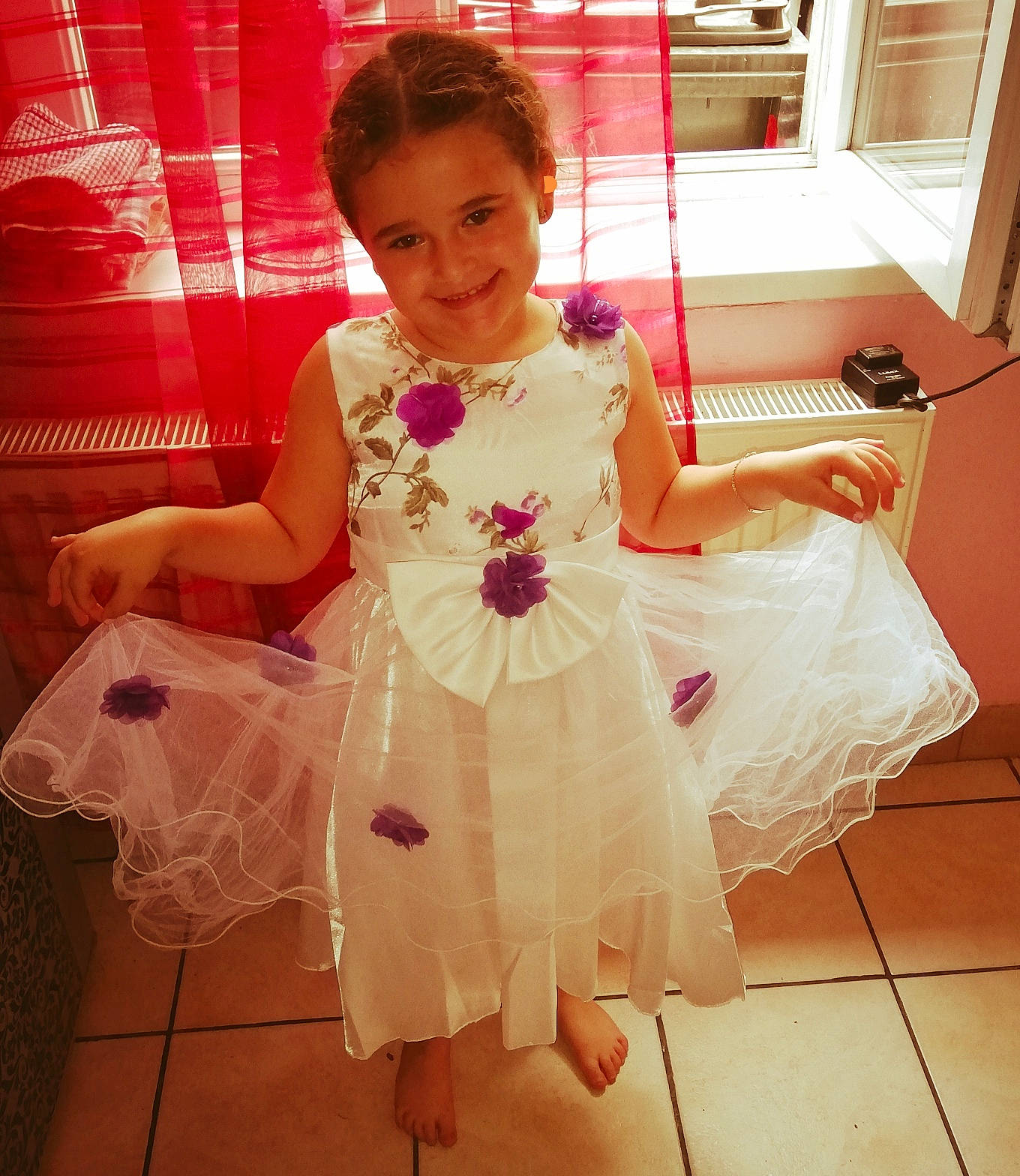 Elyana a rejoint le concours — aidez-le/la à gagner de superbes lots ! arm, baby_toddler_clothing, bridal_accessory, bridal_clothing, dress, embellishment, flooring, fun, gown, hand, happy, human_body, joy, person, pink, shoulder, sleeve, smile, textile, toddler