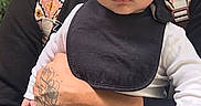 Isaac is registered to the contest to win money with this photo: baby, infant, child, hat, bib, tattoo, hand, person, adult, holding, outdoor, nature, backpack, clothing, serious, face, portrait, cute, young, casual