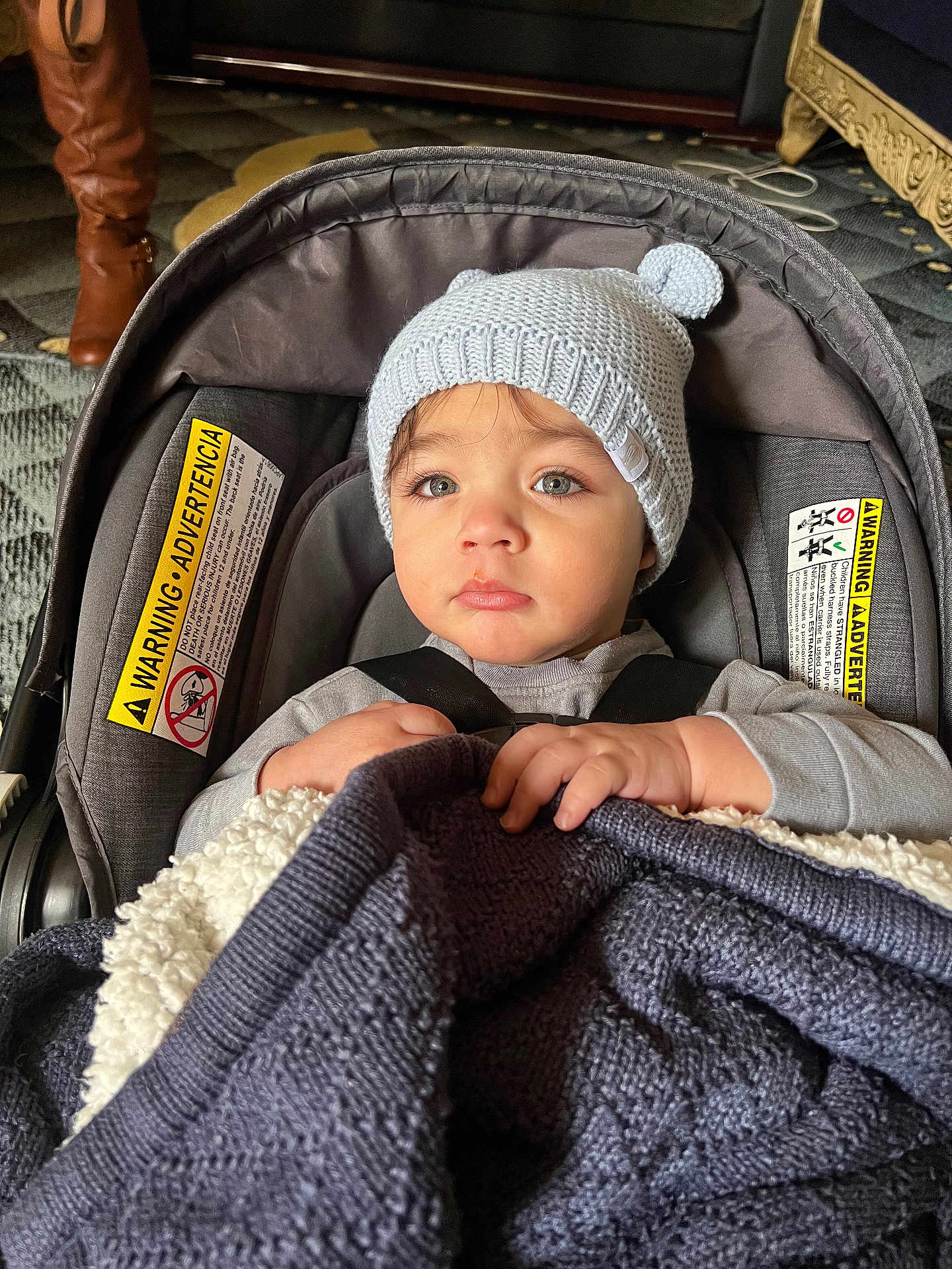Isaac joined the competition — help win amazing prizes! baby, child, car_seat, hat, knit_hat, blanket, indoor, toddler, face, person, clothing, sitting, hands, eyes, warm, cozy, seatbelt, cute, portrait, infant