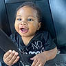 baby, child, car_seat, seatbelt, black_shirt, blue_jeans, happy, smiling, hands, face, eyes, curly_hair, infant, sitting, indoors, car_interior, safety, cute, portrait, person
