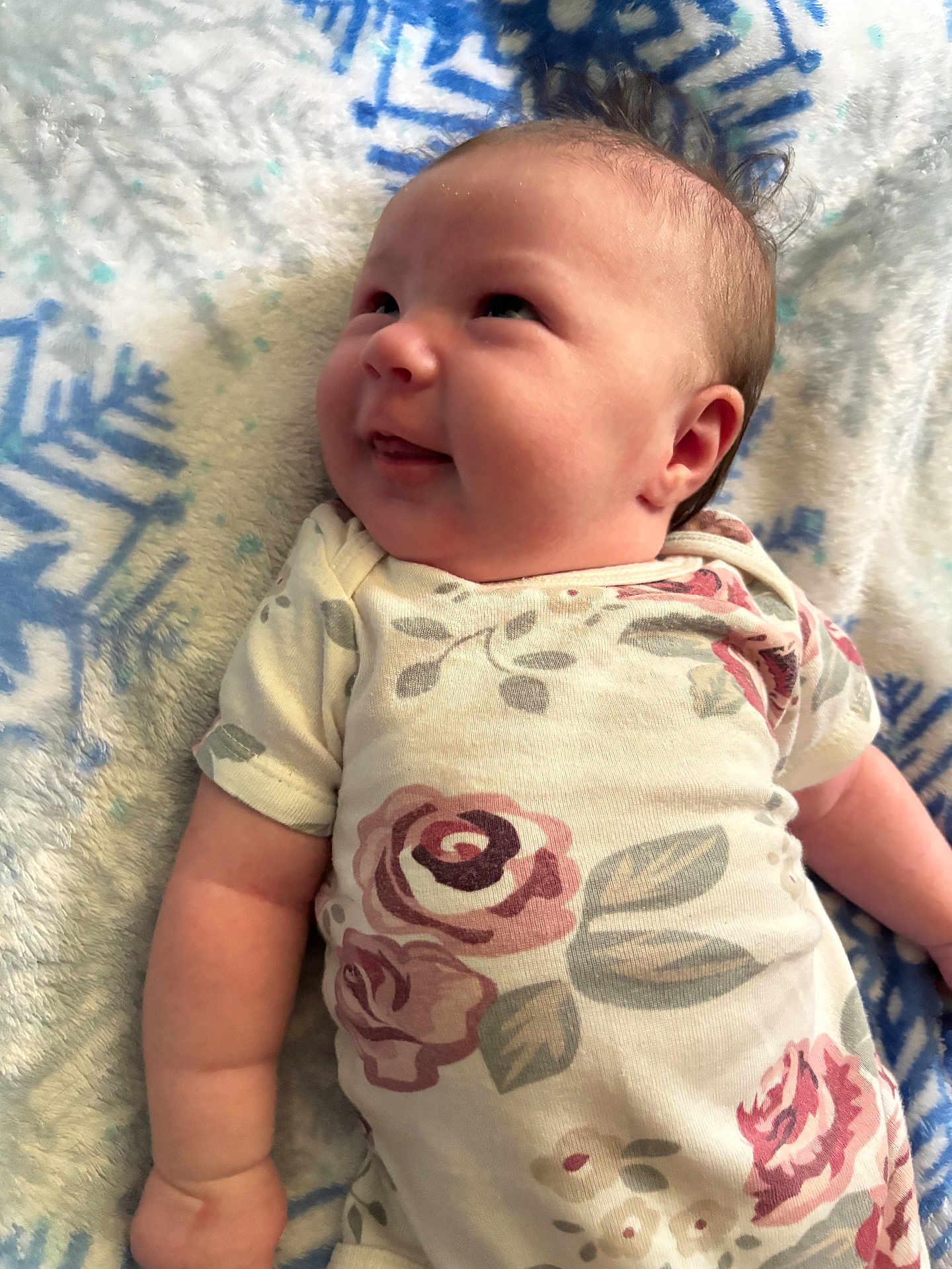 Amrynn is registered to the contest to win money with this photo: baby, infant, smile, face, clothing, onesie, flower_pattern, blanket, snowflake_pattern, lying_down, cute, chubby_cheeks, toddler, skin, head, arm, happy, indoor, portrait, young_child