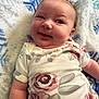 Amrynn is registered to the contest to win money with this photo: baby, infant, onesie, floral_pattern, blanket, blue, snowflake_pattern, cheeks, smile, face, skin, arm, lying_down, cute, expression, clothing, soft_texture, indoors, child, person