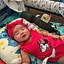 Arely is registered to the contest to win money with this photo: baby, infant, smiling, red_clothing, headband, play_mat, pillow, toy, blanket, indoor, cute, child, person, happy, lying_down, colorful, soft_toys, mickey_mouse, headwear, cheerful