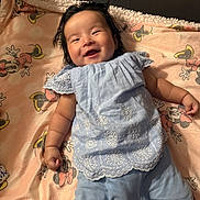 Arely joined the competition — help win amazing prizes! baby, smiling, infant, blue_clothing, blanket, cartoon_characters, lying_down, happy, cute, indoors, soft_texture, face, child, portrait, person, small_hands, cozy, bright, comfortable, sleepwear
