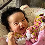 baby, bed, blanket, child, clothing, comfort, cute, face, hand, happy, head, indoors, infant, patterned, pink, plush_toy, portrait, smiling, soft_toy, toy