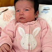 Arely joined the competition — help win amazing prizes! baby, infant, pink_onesie, bunny_design, cute, child, face, hair, hand, blanket, sleepwear, portrait, cozy, soft, indoor, young_child, adorable, expression, newborn, baby_girl