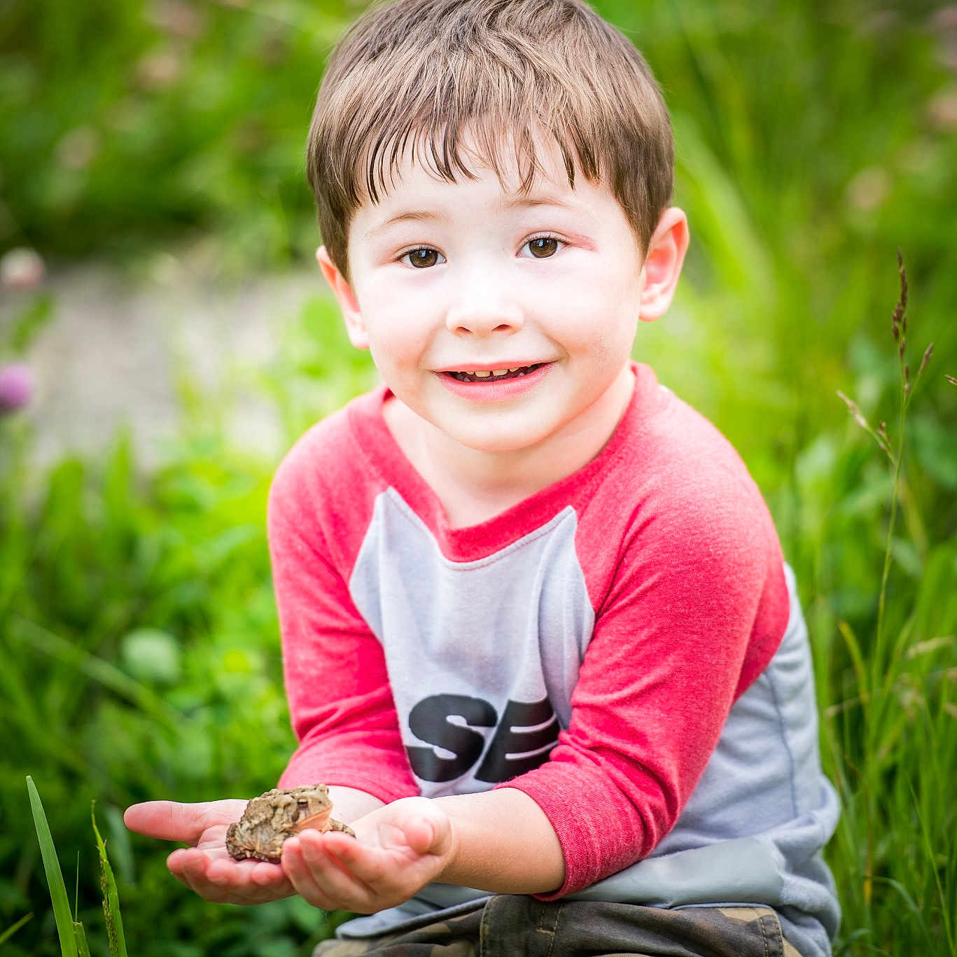 Case is registered to the contest to win money with this photo: baby, cheek, child, eye, face, facial_expression, grass, grass_family, green, happy, people, people_in_nature, photograph, photography, pink, sitting, skin, smile, spring, toddler