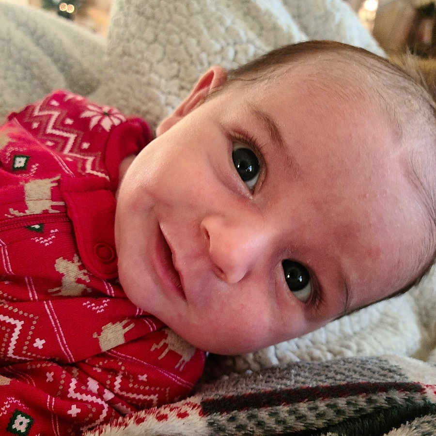 Finnegan is registered to the contest to win money with this photo: baby, blanket, bodypart, clothing, couch, cushion, face, finger, furniture, hand, happy, head, homedecor, newborn, pajamas, person, photography, portrait, quilt, smile