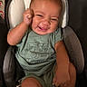 baby, baby_seat, child, cushion, cute, expression, face, fist, green_clothing, happy, indoor, infant, joy, onesie, person, portrait, seat, smiling, wearing, young_child