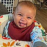 baby, baby_chair, bib, child, colorful, cozy, cute, furniture, happy, indoor, lamp, laundry_basket, living_room, pajamas, patterned, person, smiling, television, tongue_out, wood_floor