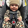 baby, child, infant, smiling, happy, portrait, car_seat, safety_harness, hat, bear_hat, leopard_print, clothing, hands, eyes, face, indoor, seated, photography, car_interior, warning_label