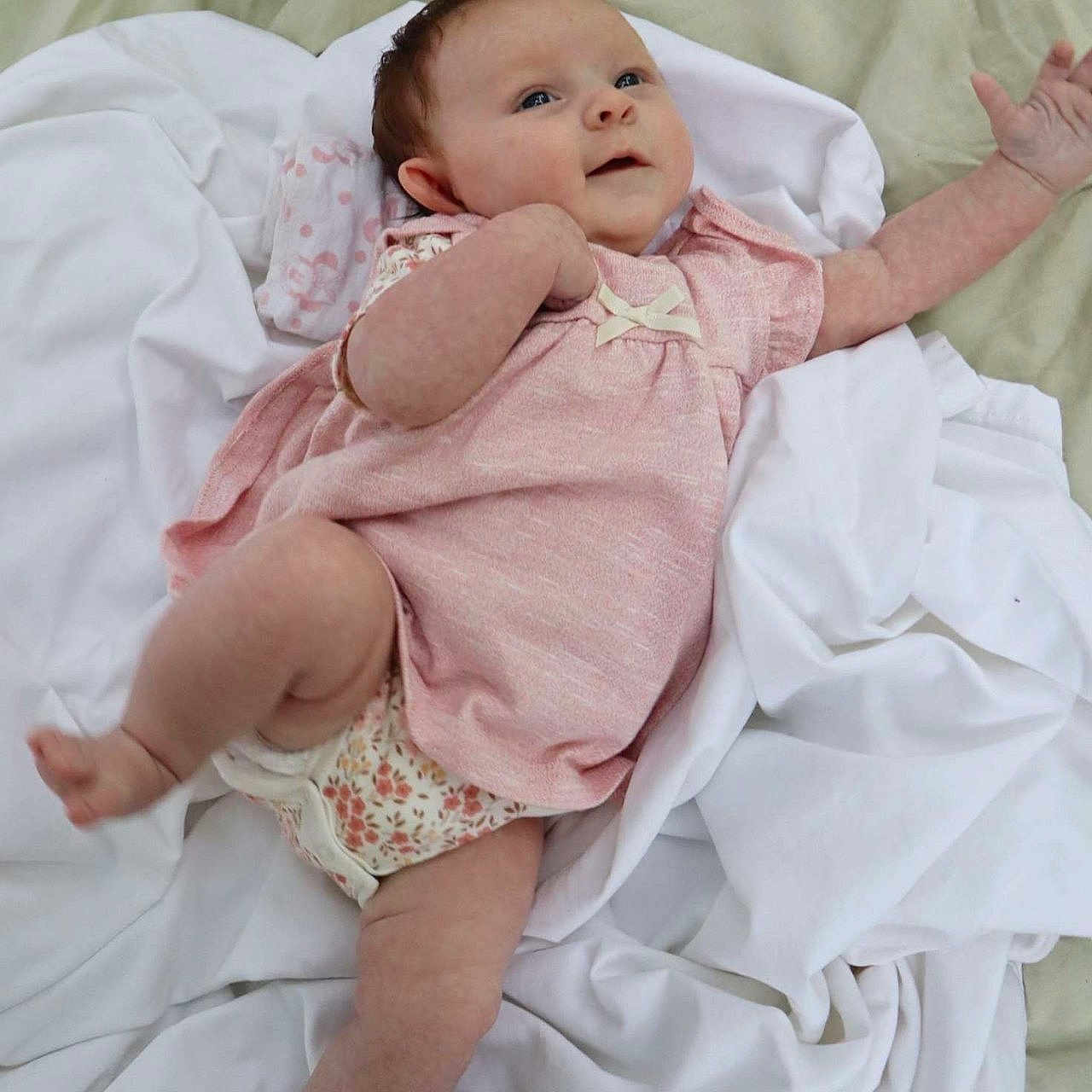 Paisley joined the competition — help win amazing prizes! arm, baby, blanket, child, cozy, cute, face, happy, indoors, infant, leg, lying_down, newborn, pink_clothing, playful, portrait, skin, smiling, soft, white_fabric