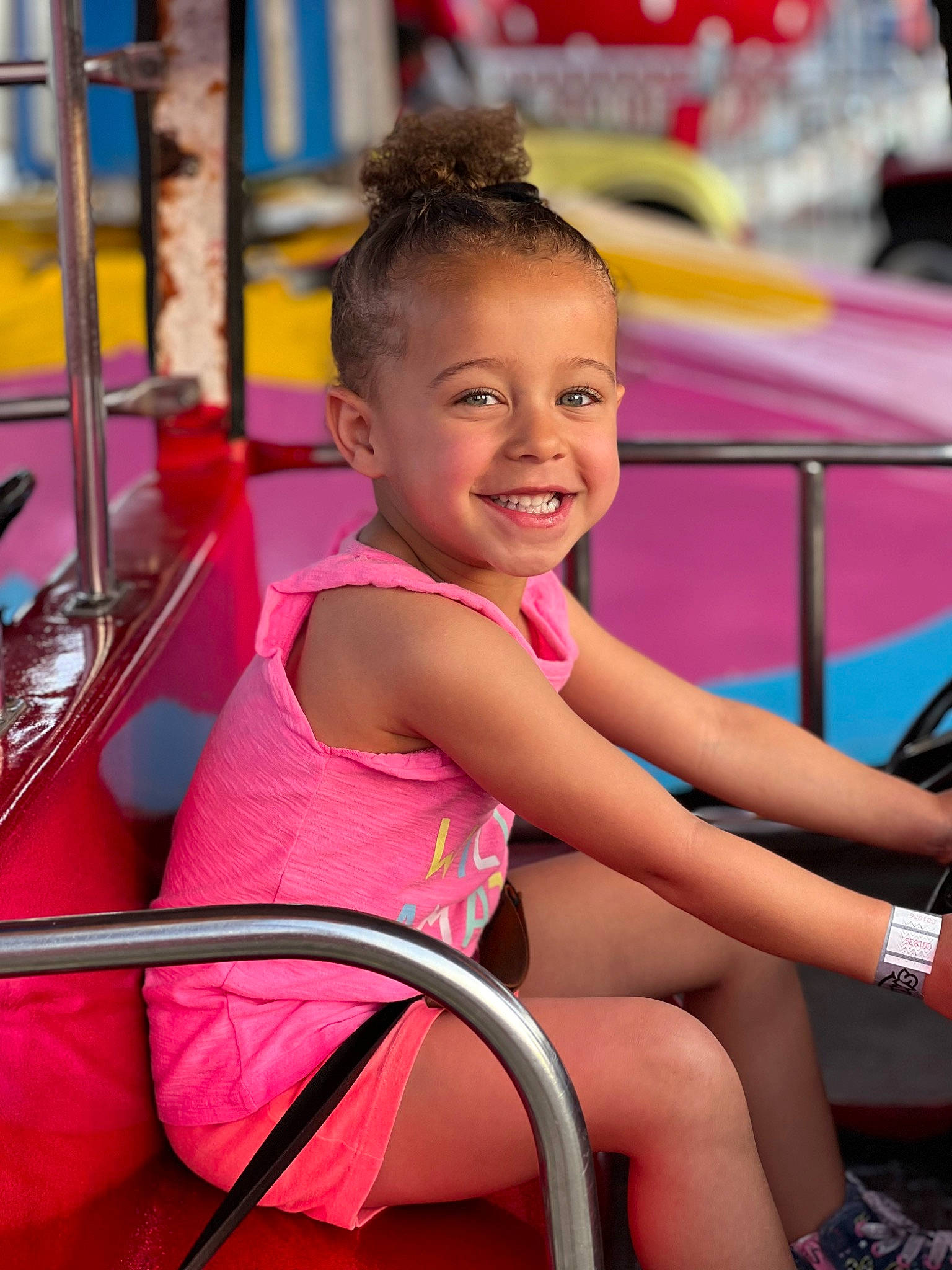 Alexandra is registered to the contest to win money with this photo: chair, child, event, fun, happy, human_leg, joy, lap, leg, leisure, magenta, motor_vehicle, person, pink, public_space, recreation, sitting, skin, smile, summer