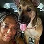 woman, dog, car_interior, selfie, smiling, braided_hair, tongue_out, pet, companion, friendship, seat, collar, portrait, indoor, closeup, face, canine, human, happy, together