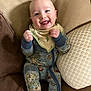 Levi joined the competition — help win amazing prizes! baby, smiling, onesie, bib, couch, pillow, happy, infant, clothing, indoor, person, cute, child, portrait, seated, furniture, playful, young, cozy, comfortable