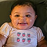 baby, infant, child, smiling, portrait, face, eyes, teeth, hair, strawberry, clothing, shirt, sleeves, cushion, indoors, sitting, happy, close_up, photography, ai_generated_content