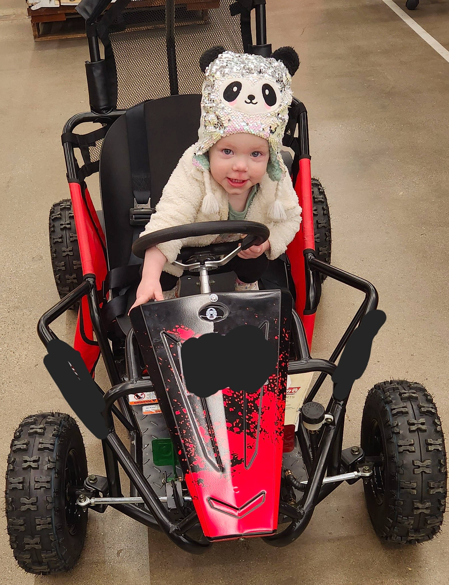 Jaelynn is registered to the contest to win money with this photo: automotive_design, automotive_exterior, automotive_tire, black, car, fender, head, headwear, joy, motor_vehicle, motorsport, person, racing, rim, rolling, smile, sports, synthetic_rubber, tire, toddler