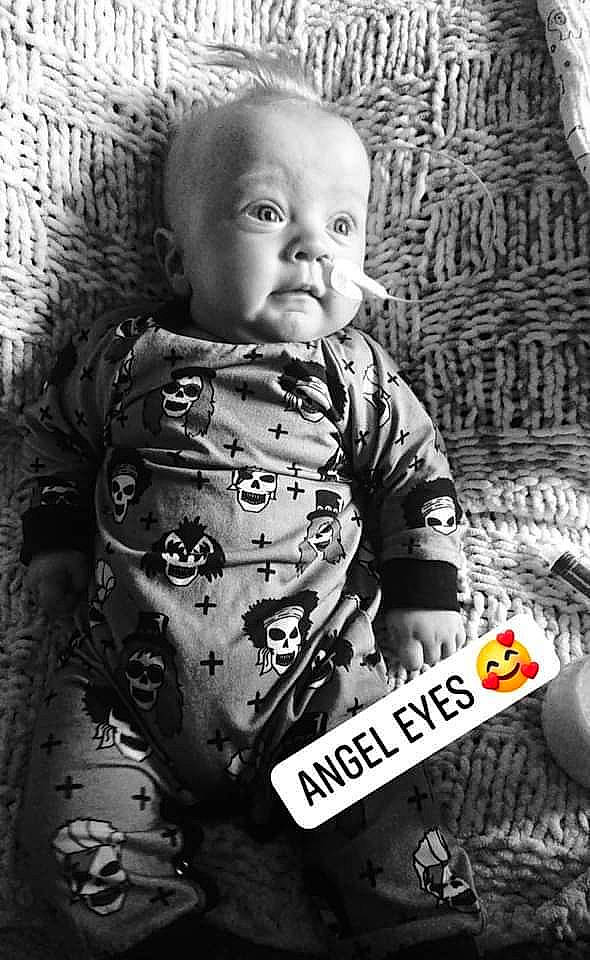 Leonidas is registered to the contest to win money with this photo: arm, baby, black, black_and_white, cheek, comfort, eye, facial_expression, flash_photography, hairstyle, iris, mouth, organ, outerwear, person, photograph, shirt, skin, sleeve, textile