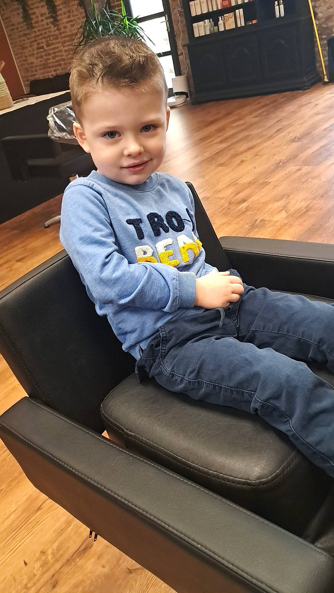 Clayton a rejoint le concours — aidez-le/la à gagner de superbes lots ! baby_toddler_clothing, child, comfort, electronic_device, face, floor, flooring, gadget, hardwood, human_leg, joy, knee, leg, person, sitting, sleeve, smile, sportswear, t_shirt, thigh