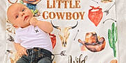 Ryker is registered to the contest to win money with this photo: arrow, baby, bandana, blanket, boots, cactus, child, clothing, cowboy, cowboy_hat, cute, horseshoe, infant, jeans, lying_down, portrait, skull, western_theme, white_shirt, wild_and_free