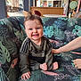 baby, smiling, cute, indoor, couch, floral_pattern, happy, person, child, clothing, hand, window, light, hair, foot, seated, support, interior, adidas, tooth