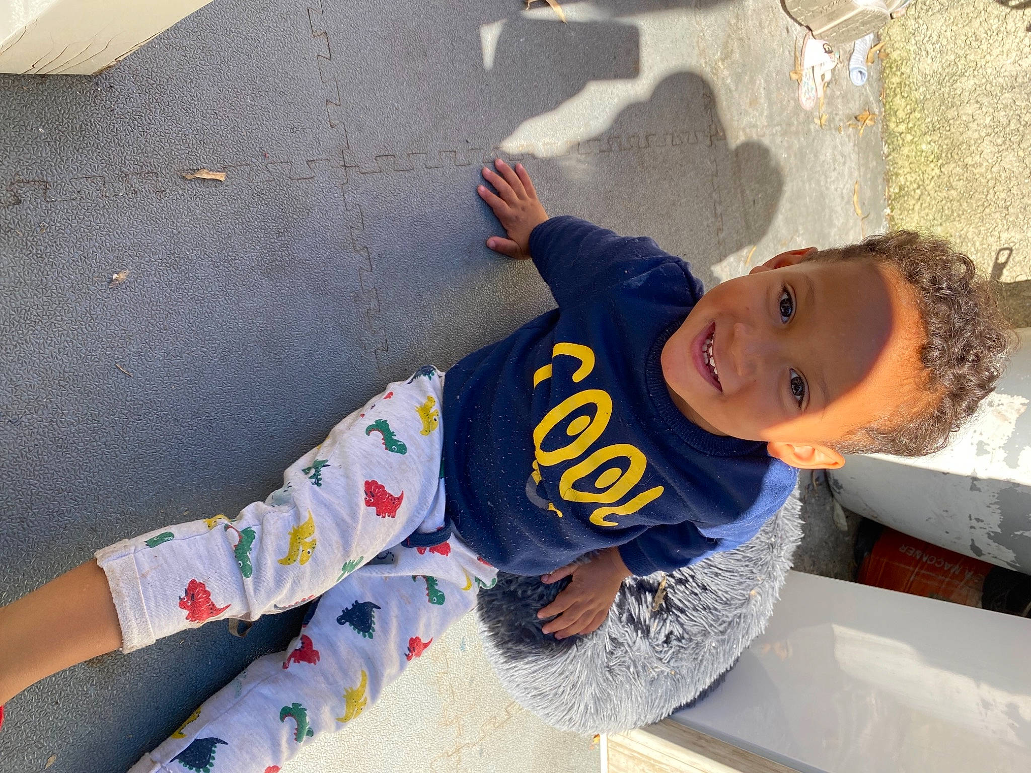 Daëvon participe au concours pour gagner de l'argent avec cette photo : asphalt, baby_toddler_clothing, child, concrete, foot, fun, happy, hat, human_leg, joy, leisure, pattern, person, recreation, sitting, sleeve, smile, t_shirt, thigh, toddler