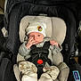 Jace is registered to the contest to win money with this photo: baby, infant, car_seat, hat, white_hat, clothing, socks, straps, harness, indoor, cute, newborn, seat, protection, child, person, small, cozy, resting, sitting