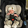 baby, infant, car_seat, hat, clothing, socks, straps, safety, indoor, person, cute, newborn, seated, car_seat_harness, expression, small, soft, blanket, comfort, headwear
