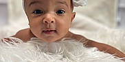Irie is registered to the contest to win money with this photo: baby, headband, white_bow, fluffy, soft_texture, infant, portrait, close_up, face, cute, child, innocent, curious, indoors, soft_lighting, background_blur, skin, expression, newborn, toddler