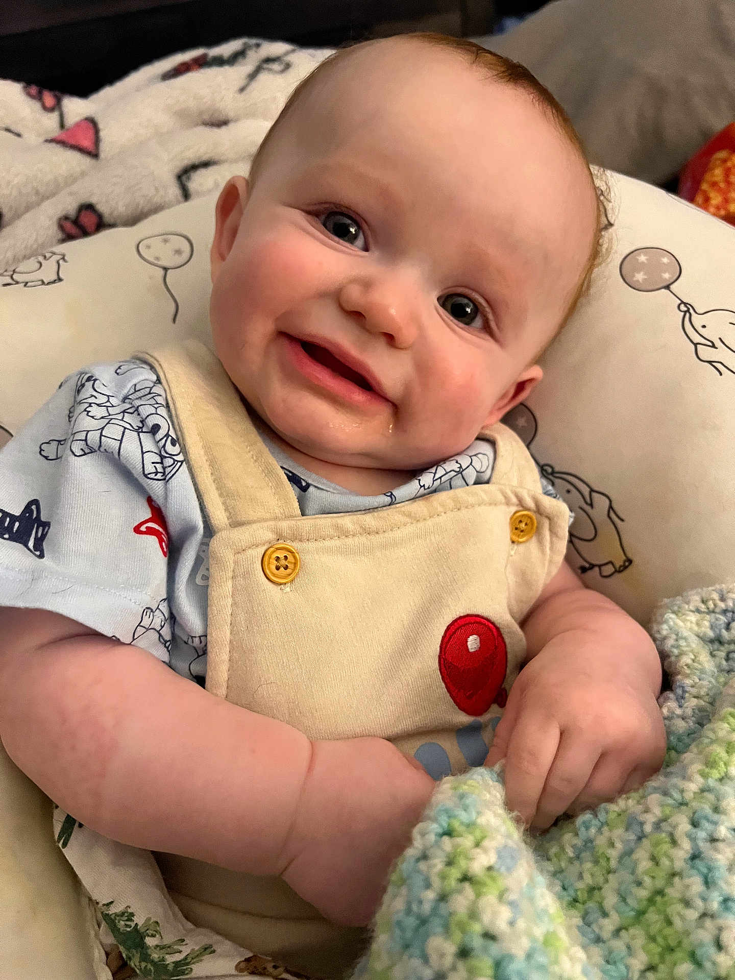 Matteo Peter Noel is registered to the contest to win money with this photo: baby, smile, drool, blanket, overalls, balloon_patch, cushion, pattern, elephant, balloon, cute, child, infant, clothing, hand, face, eyes, indoor, soft, cozy