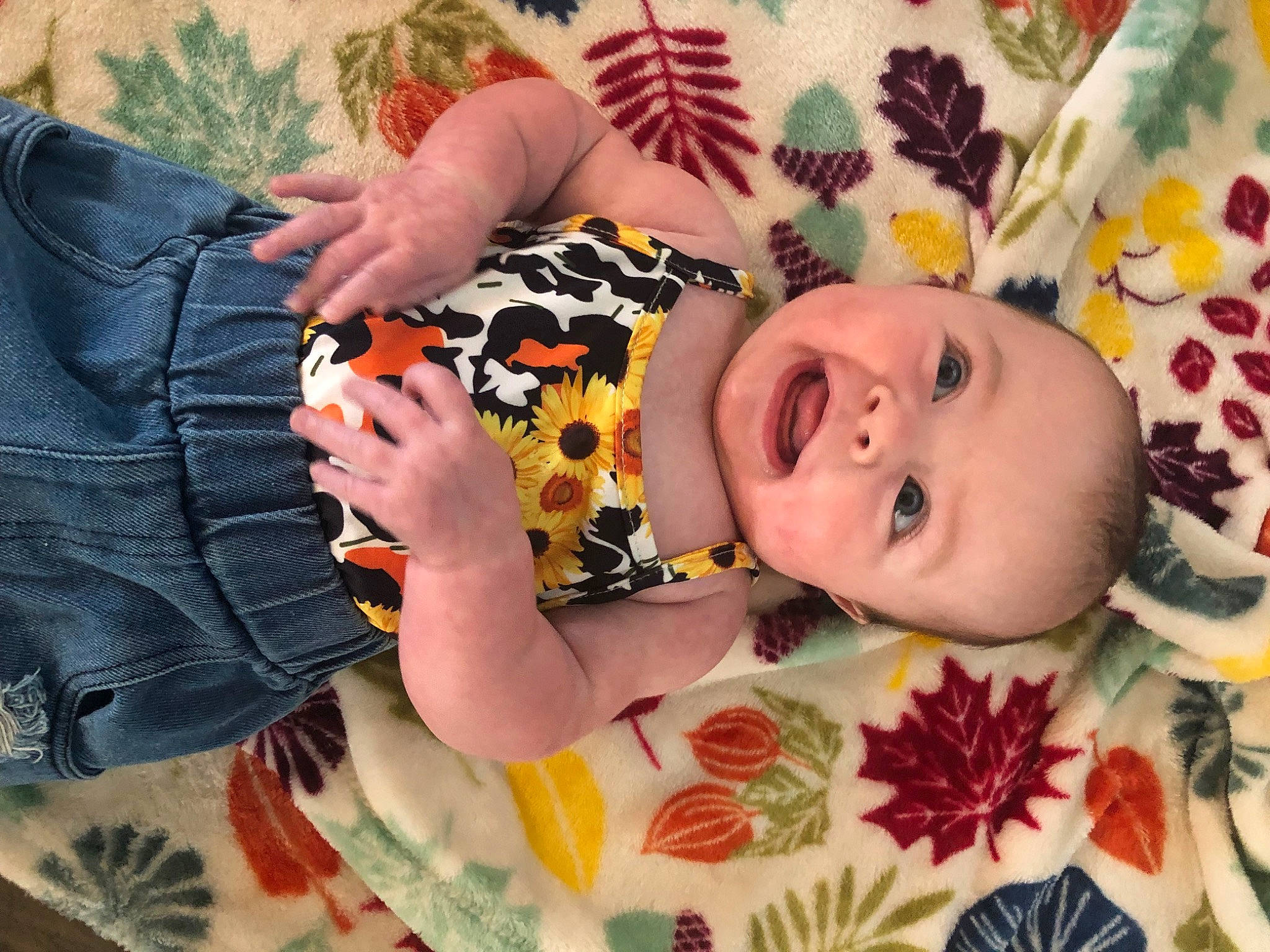 Cayson is registered to the contest to win money with this photo: arm, baby, baby_products, baby_toddler_clothing, cheek, comfort, eye, face, facial_expression, finger, hand, happy, head, linens, pattern, person, skin, sleeve, smile, textile
