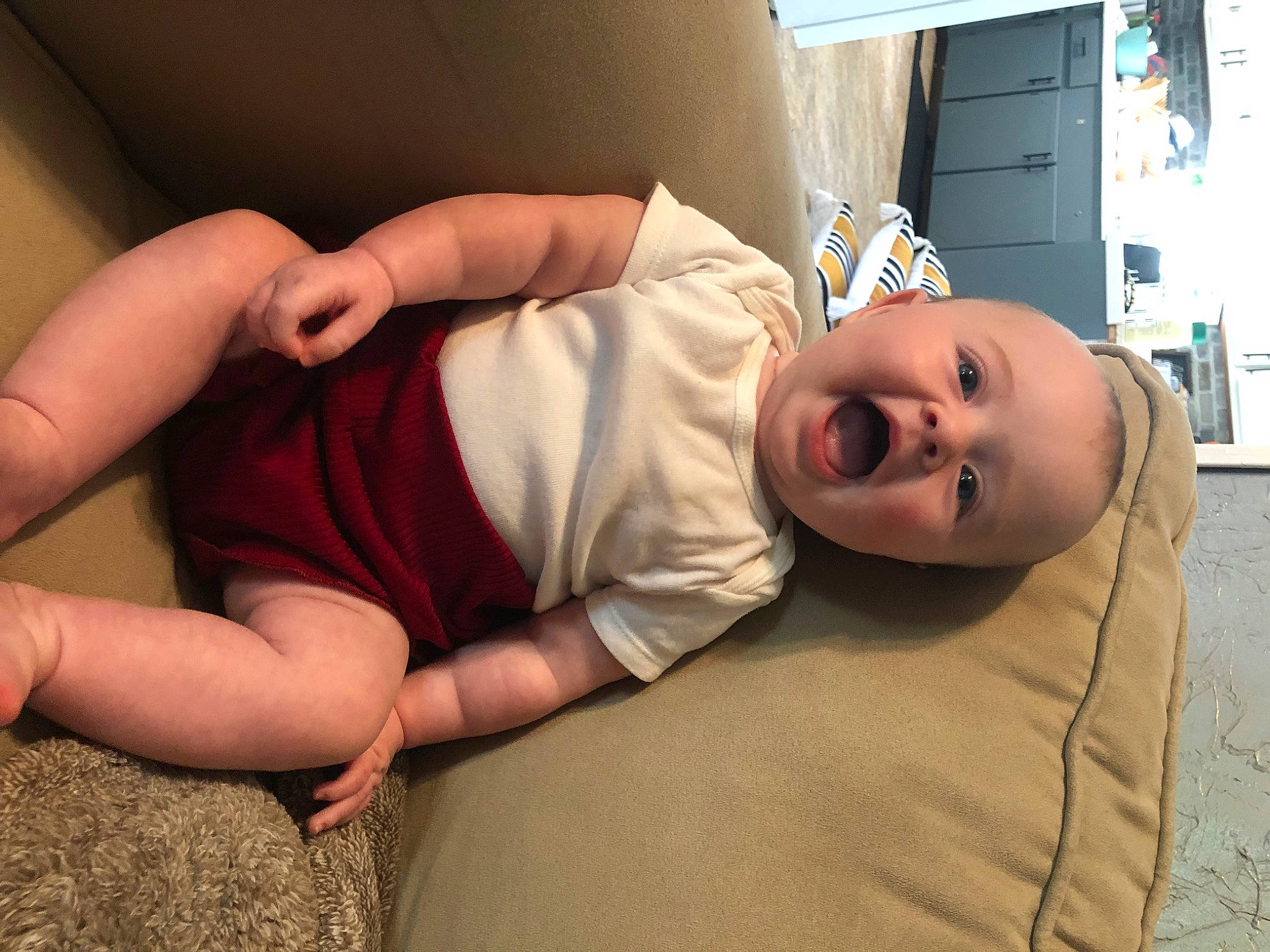 Cayson is registered to the contest to win money with this photo: arm, baby, comfort, couch, finger, floor, fun, gesture, hand, hat, human, human_body, joint, leg, mammal, mouth, person, shoulder, skin, smile