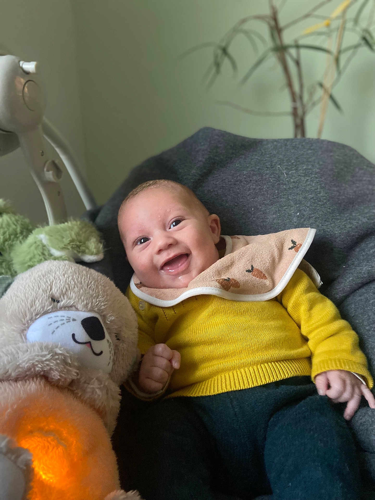Noé participe au concours pour gagner de l'argent avec cette photo : baby, smiling, yellow_sweater, bib, plush_toy, glowing_toy, gray_blanket, cozy, indoor, child, happy, cute, infant, soft_toy, portrait, seated, warm_light, toy_bear, candid, comfort