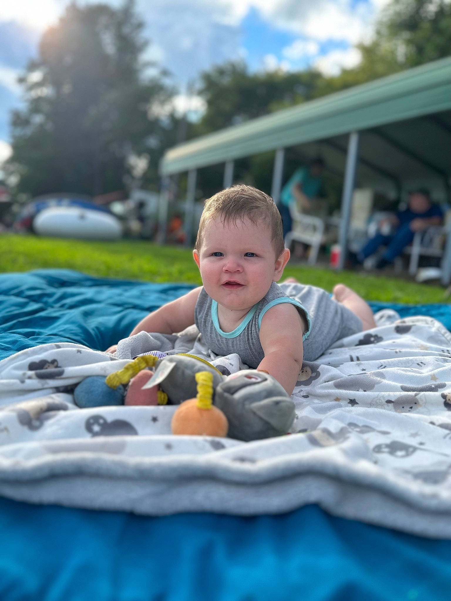 Jason is registered to the contest to win money with this photo: baby, child, city, cloud, event, fun, grass, happy, leisure, outdoor_recreation, person, plant, play, recreation, sitting, sky, smile, t_shirt, toddler, travel