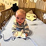 Louis a rejoint le concours — aidez-le/la à gagner de superbes lots ! baby, baby_toy, blanket, blue_sheet, child, cozy, crawling, crib, cute, face, happy, indoor, infant, nursery, person, plush_toys, smiling, soft_toy, striped_sweater, wooden_crib