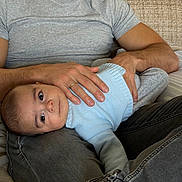 Louis participe au concours pour gagner de l'argent avec cette photo : baby, adult, man, child, couch, sweater, jeans, holding, lap, indoor, casual_clothing, beard, seated, comfort, home, portrait, relaxing, skin, hand, face