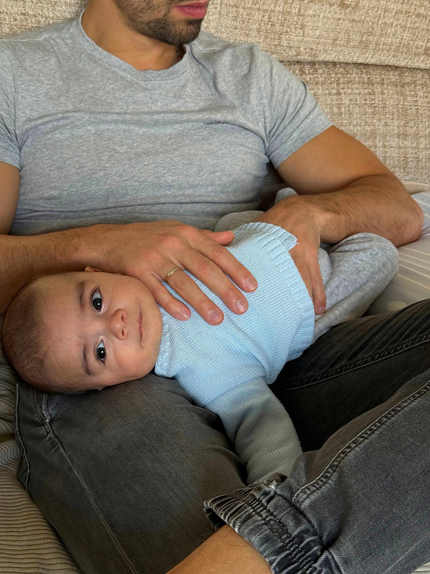 Louis participe au concours pour gagner de l'argent avec cette photo : baby, adult, man, child, couch, sweater, jeans, holding, lap, indoor, casual_clothing, beard, seated, comfort, home, portrait, relaxing, skin, hand, face
