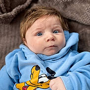 Isaïe participe au concours pour gagner de l'argent avec cette photo : baby, blanket, blond_hair, blue_hoodie, close_up, clothing, cozy, face, hand, indoors, infant, newborn, photo_app_ui, pluto_graphic, portrait, portrait_mode, skin, smartphone_screenshot, soft_texture, wide_eyes